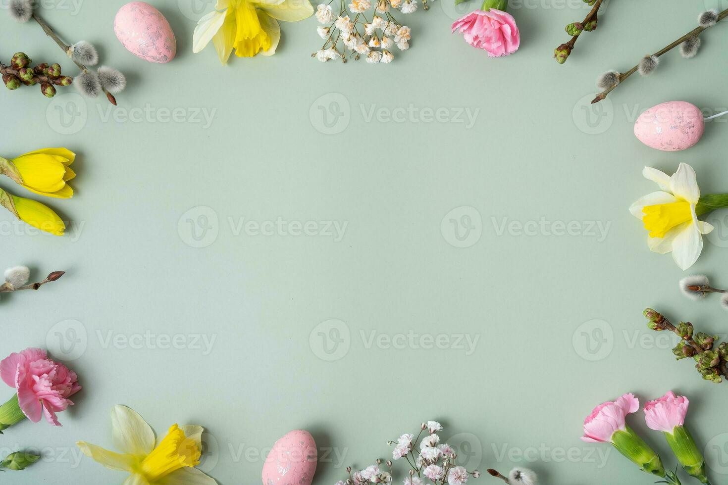 Spring flowers ans easter eggs border on green background with copy space. Easter greeting card template photo