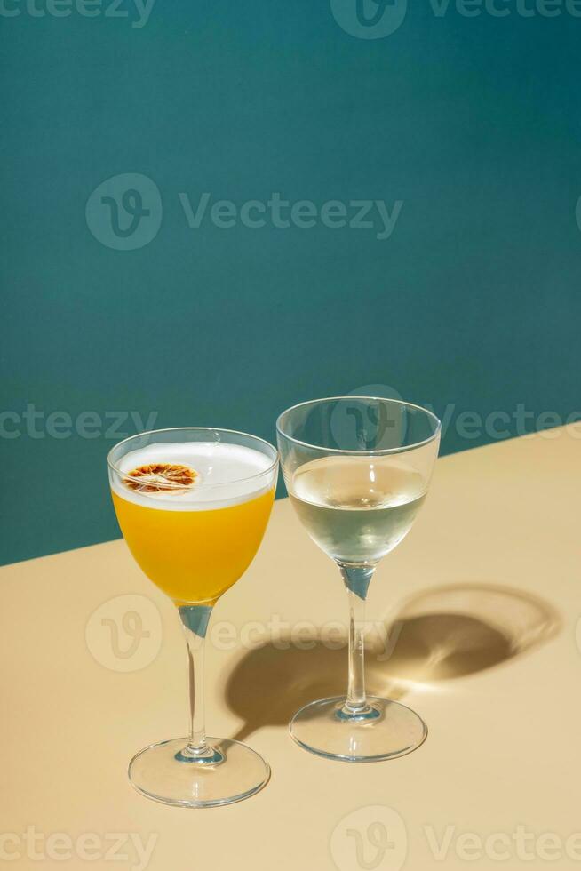 Alcoholic cocktail in two glasses on a colored background photo