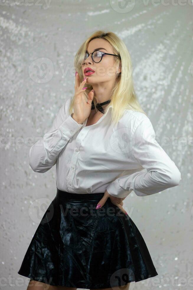 blonde woman wearing glasses and an black leather skirt photo