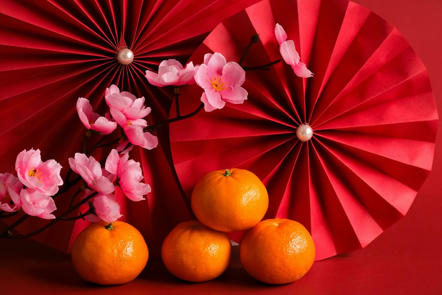 Chinese New Year of the dragon festival concept. Mandarin orange, red envelopes and gold ingot with red paper fans. Traditional holiday lunar New Year. photo