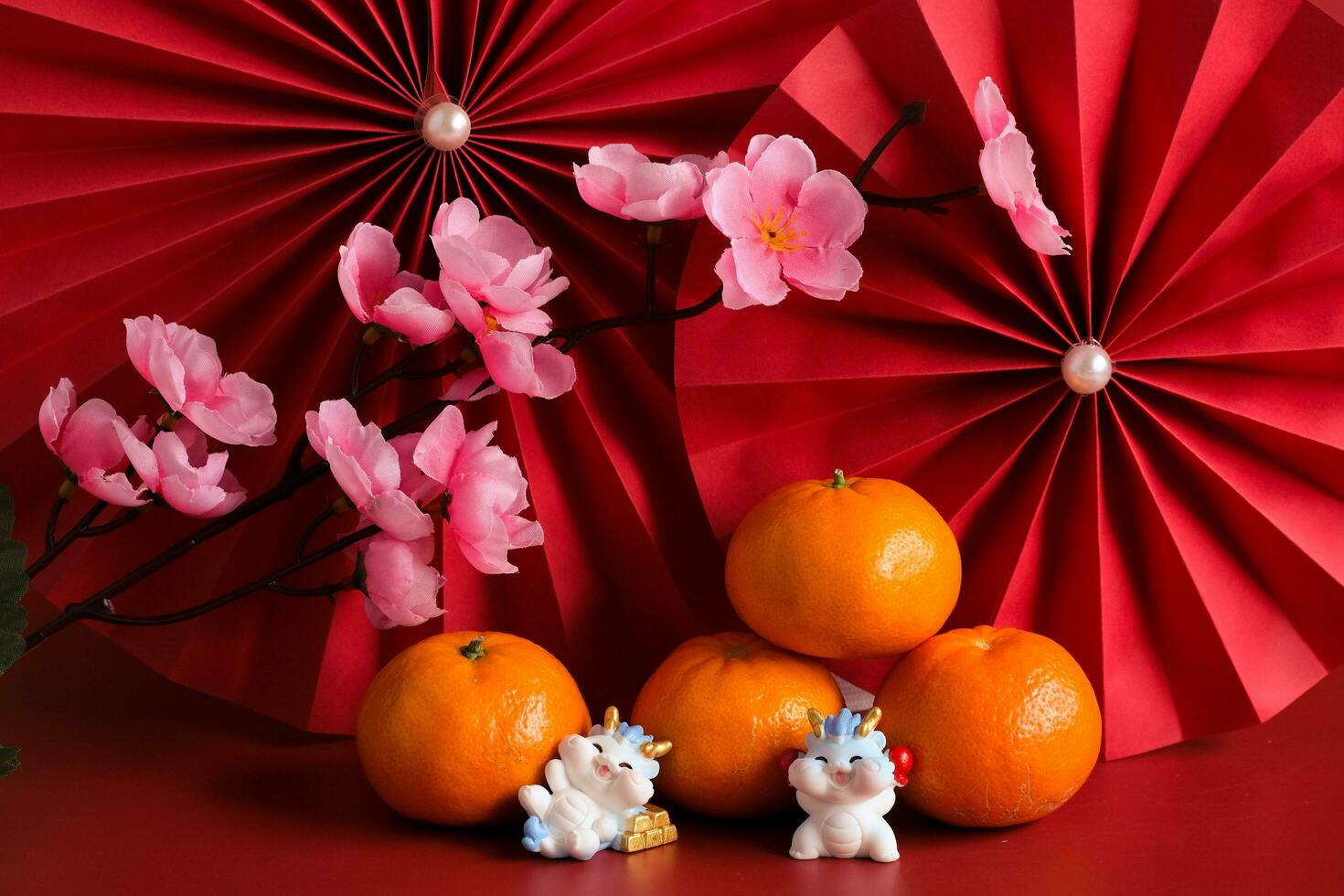 Chinese New Year of the dragon festival concept. Mandarin orange, red envelopes, dragon and gold ingot with red paper fans. Traditional holiday lunar New Year. photo