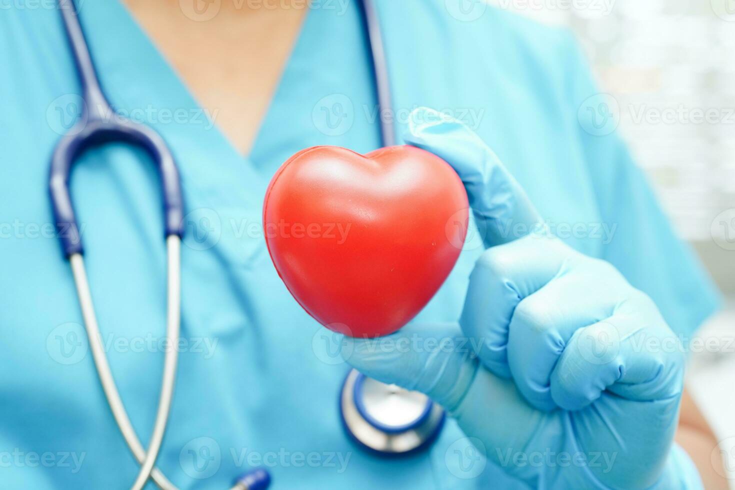 Asian woman doctor holding red heart for health in hospital. photo