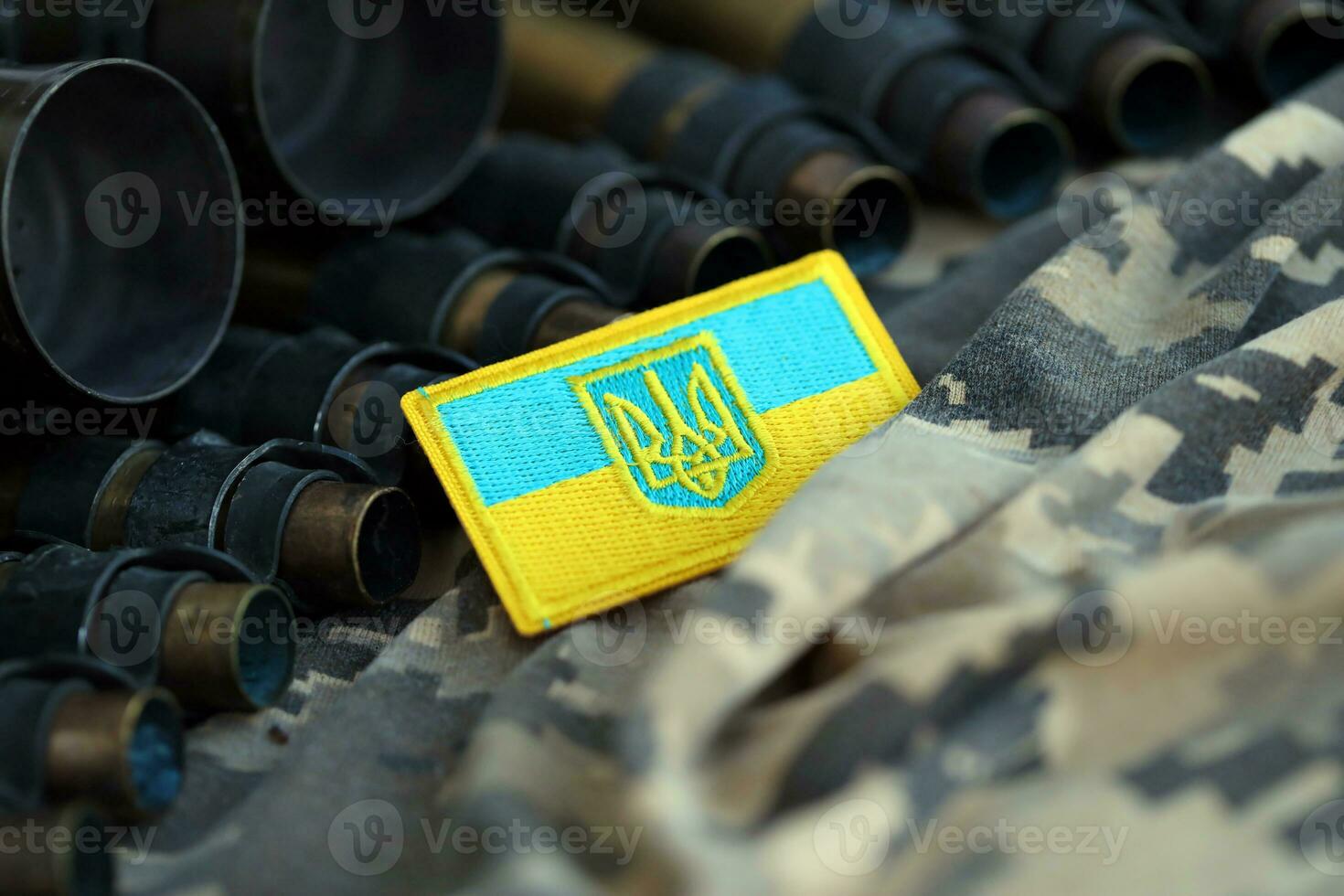 Ukrainian symbol on machine gun belt lies on ukrainian pixeled military camouflage photo