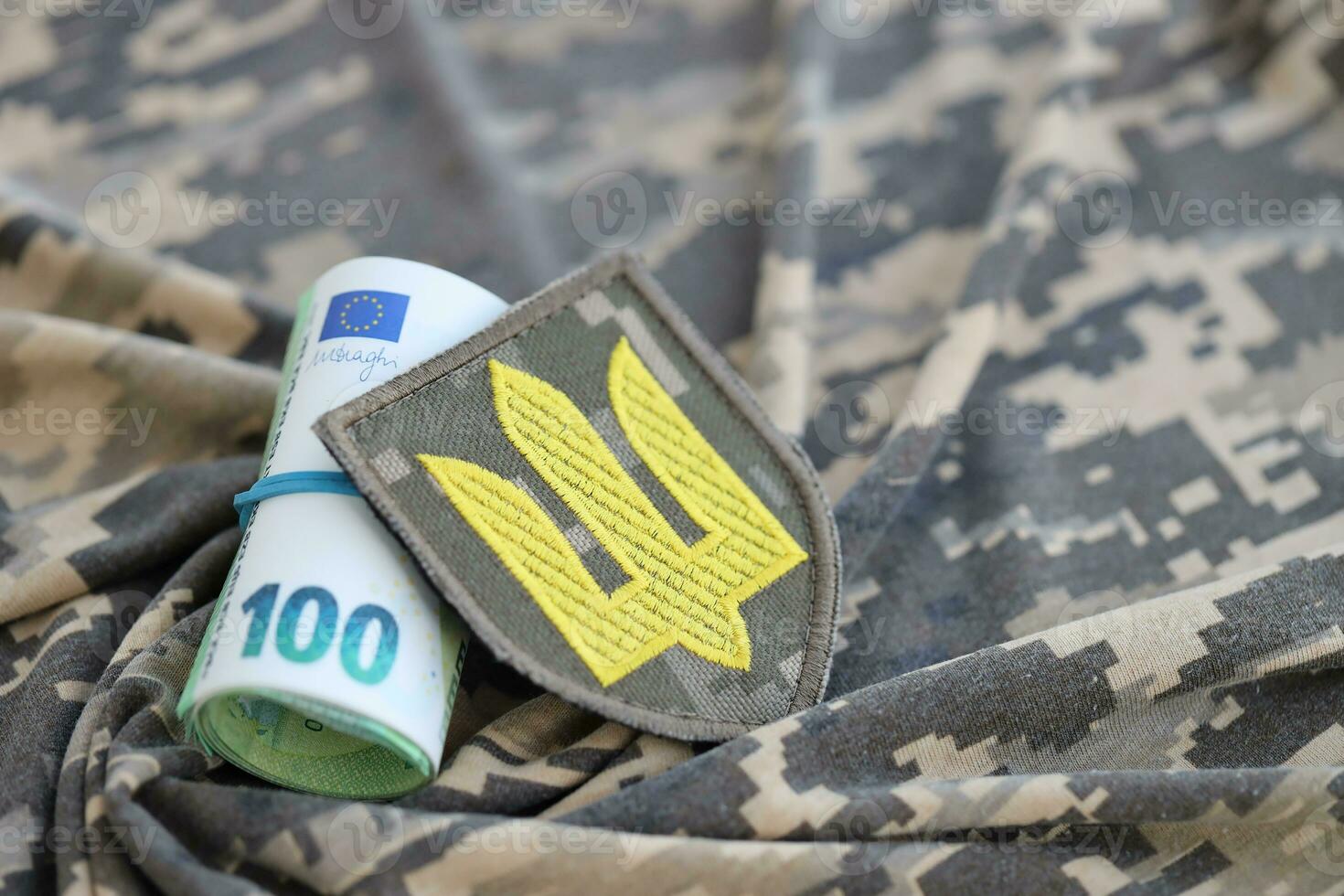 Ukrainian army symbol and bunch of euro bills on military uniform. Payments to soldiers of the Ukrainian army from European union, salaries to the military. War support photo