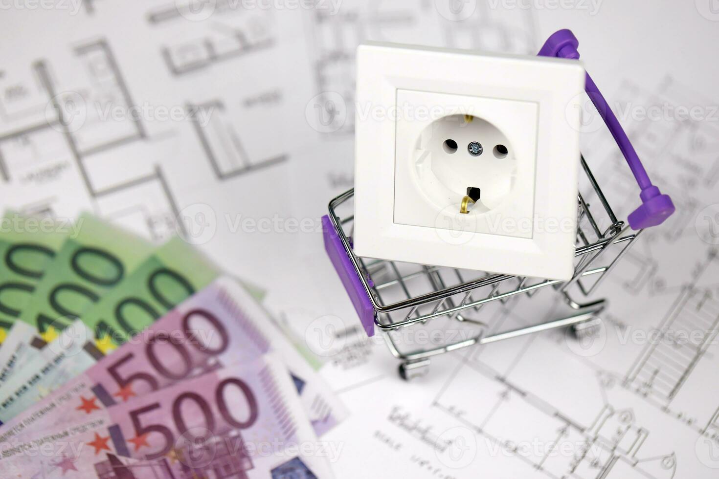 European standard EU outlet in small shopping cart on blueprints of residential house plan. Concept of shopping and electricity devices photo