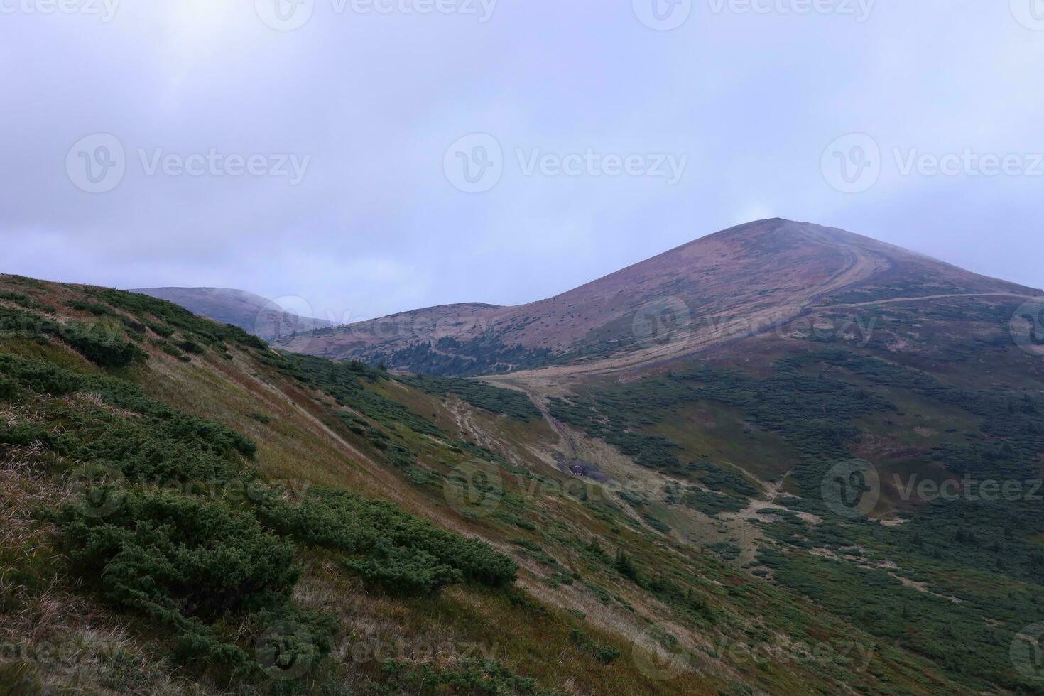 Morning view from the Dragobrat mountain peaks in Carpathian mountains, Ukraine. Cloudy and foggy landscape around Drahobrat Peaks photo