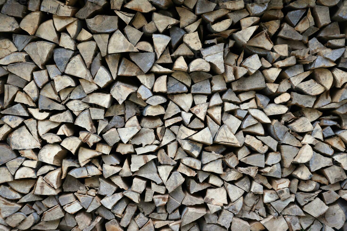 Firewood stacked near the wooden wall of old hut. Many chopped logs of firewood photo