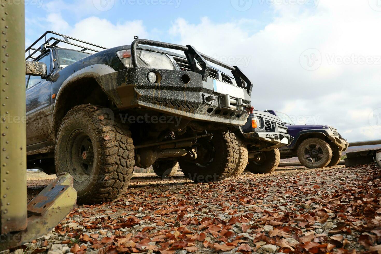 Automobile in a countryside landscape with a mud road. Off-road 4x4 suv automobile with ditry body after drive in muddy road photo