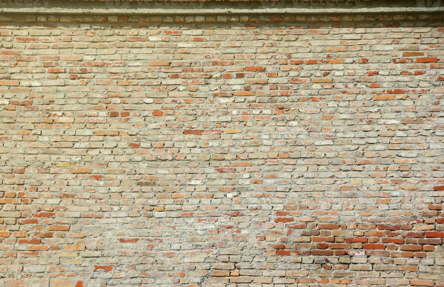 Very old brick stone wall of castle or fortress of 18th century. Full frame wall with obsolete dirty and cracked bricks photo