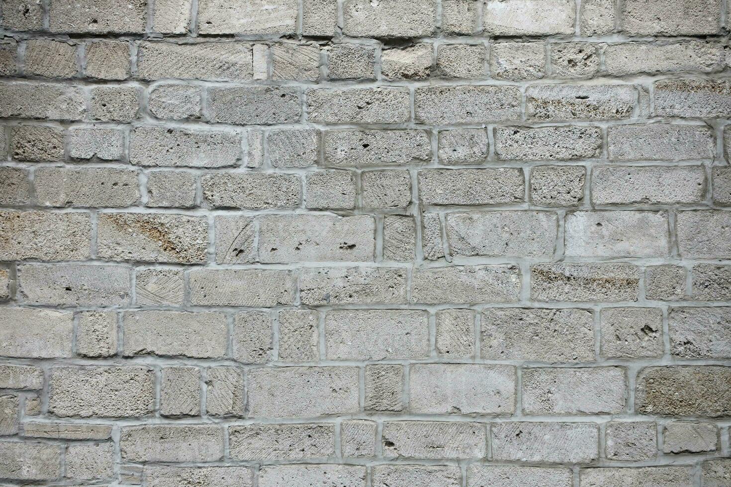 Very old brick stone wall of castle or fortress of 18th century. Full frame wall with obsolete dirty and cracked bricks photo