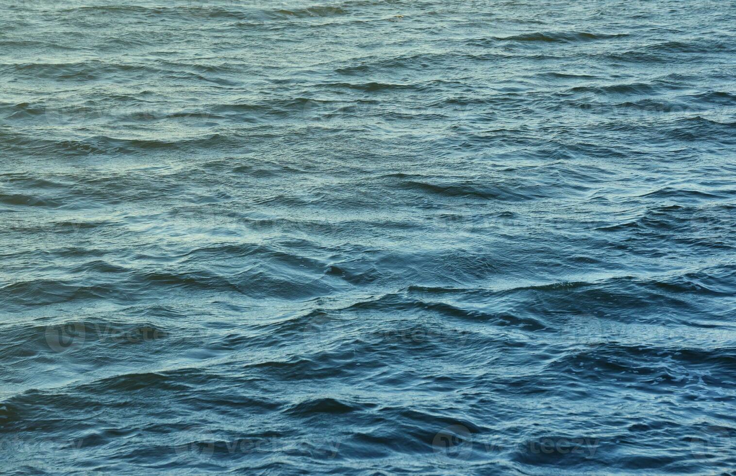 The raging waters of the river. Top view background texture of the raging elements. White foam on blue waving water photo