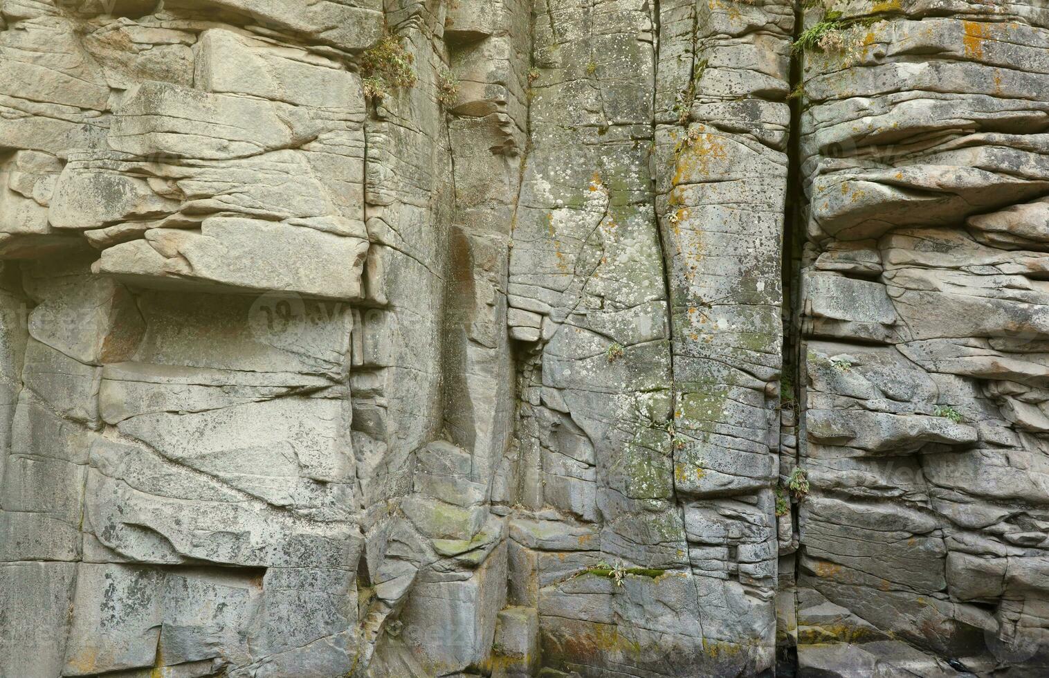 Light coarse natural rock stone background. Mining cliff rough front surface. Big limestone stack backdrop. Heavy grunge damaged granite block texture photo