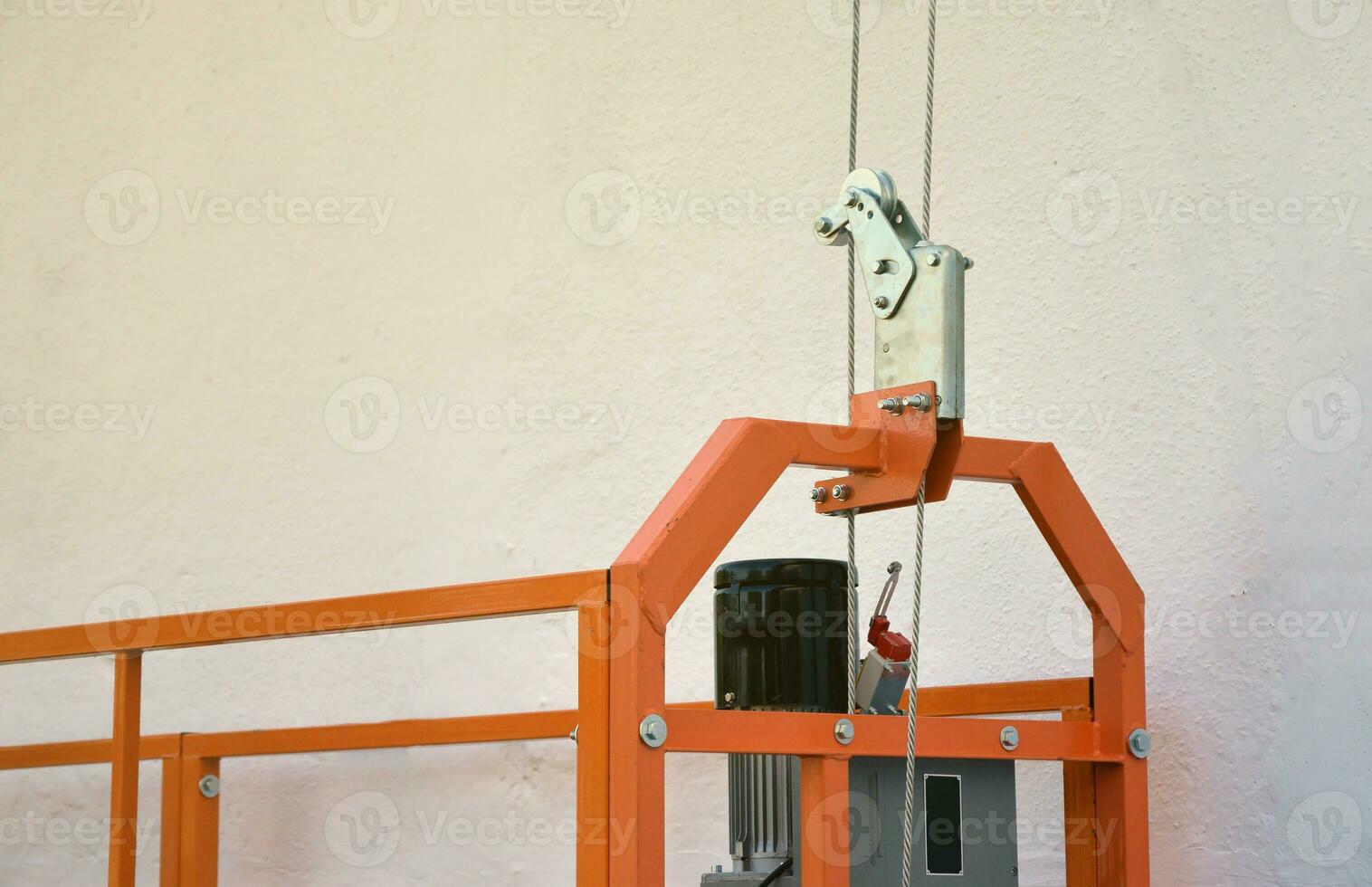 Hoist supply and safety lock as part of suspended wire rope platform for facade works on high multistorey buildings. Hoist for elevation, raising or lifting cradle photo