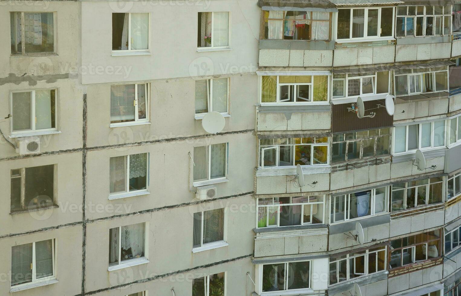 Facade of a grey multi storey soviet panel building. Russian old urban residential houses with windows and balcony. Russian neighborhood photo