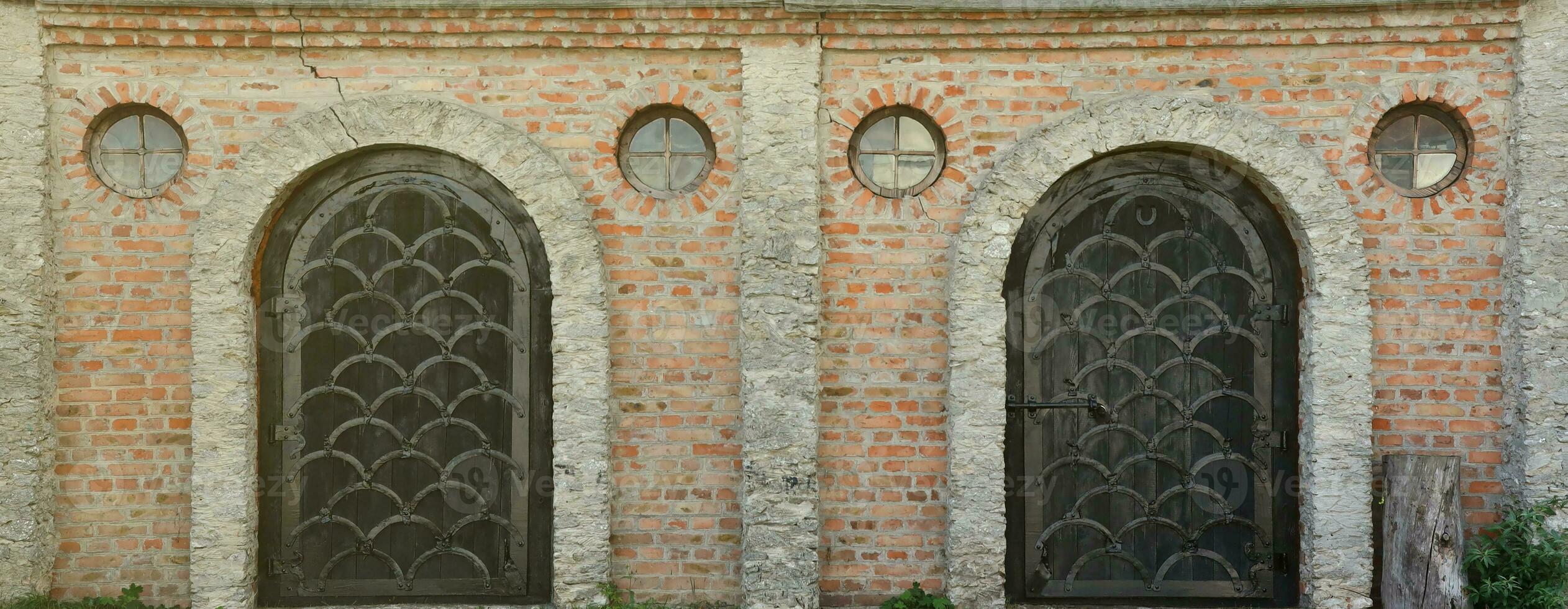 Very old solid door in brick stone wall of castle or fortress of 18th century photo