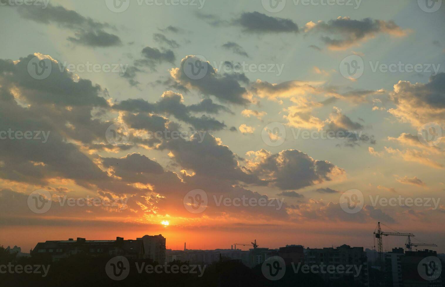 Beautiful sunrise with warm orange sunlight and beams through blue sky photo