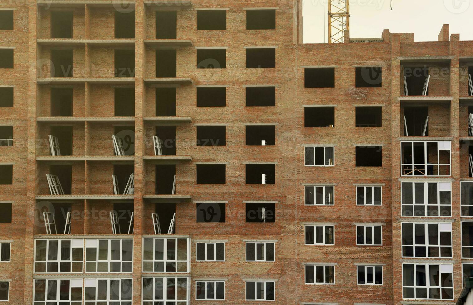 View of a large construction site with buildings under construction and multi-storey residential homes. Tower cranes in action on blue sky background. Housing renovation concept photo