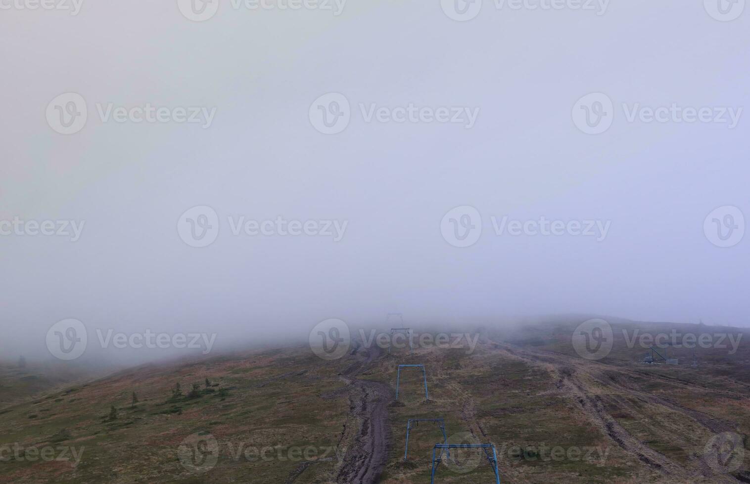 Morning view from the Dragobrat mountain peaks in Carpathian mountains, Ukraine. Cloudy and foggy landscape around Drahobrat Peaks photo