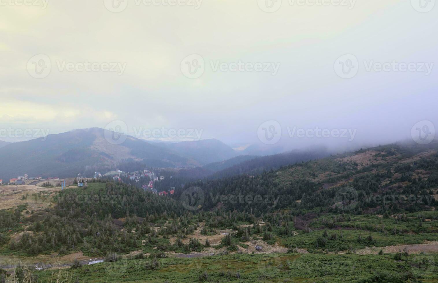 Morning view from the Dragobrat mountain peaks in Carpathian mountains, Ukraine. Cloudy and foggy landscape around Drahobrat Peaks photo
