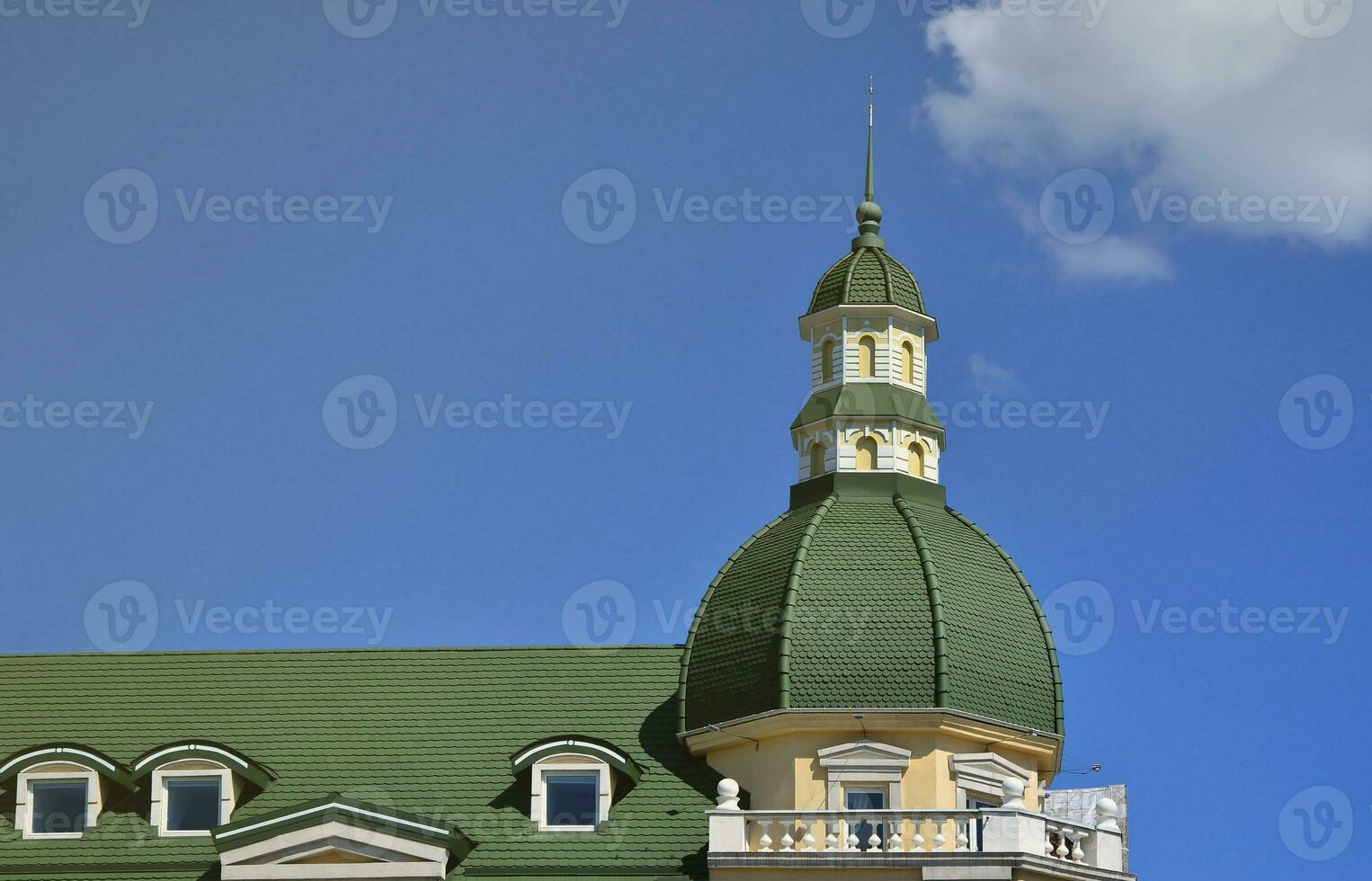 Completed perfect high-quality roofing work from metal roofing. The dome of a polyhedral shape with a spire is covered with green metal tiles photo