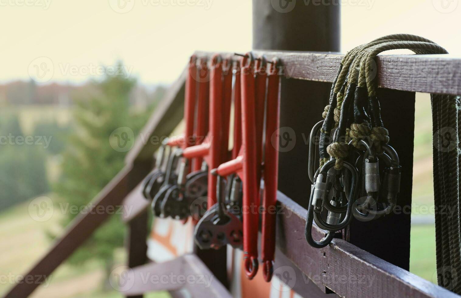 large metal locking carabiners with rope, climbing gear hanging on the store room. Height safety harness and arborist equipment photo