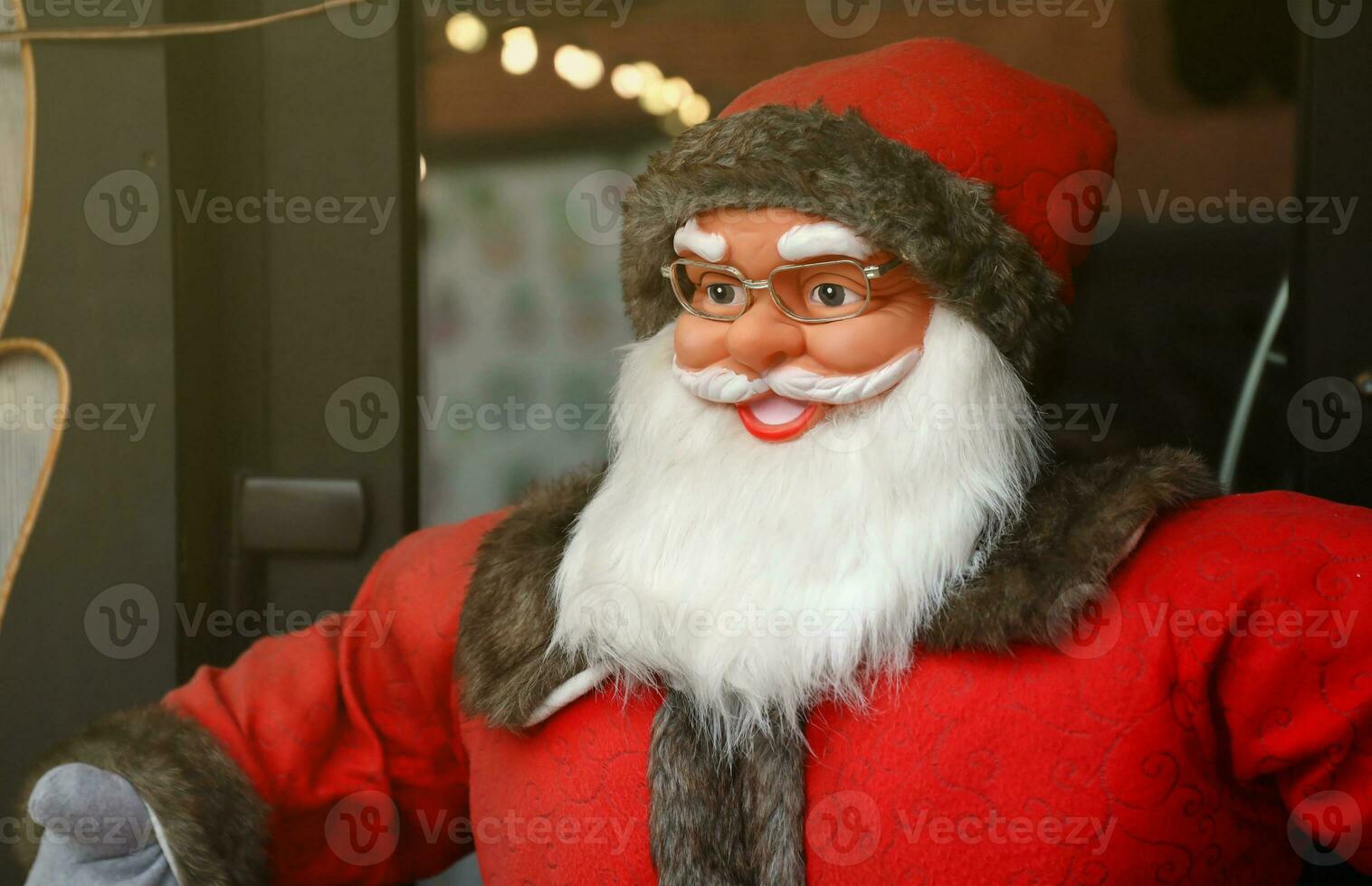 Santa claus big plastic figure with classic santa clothes close to wooden house photo