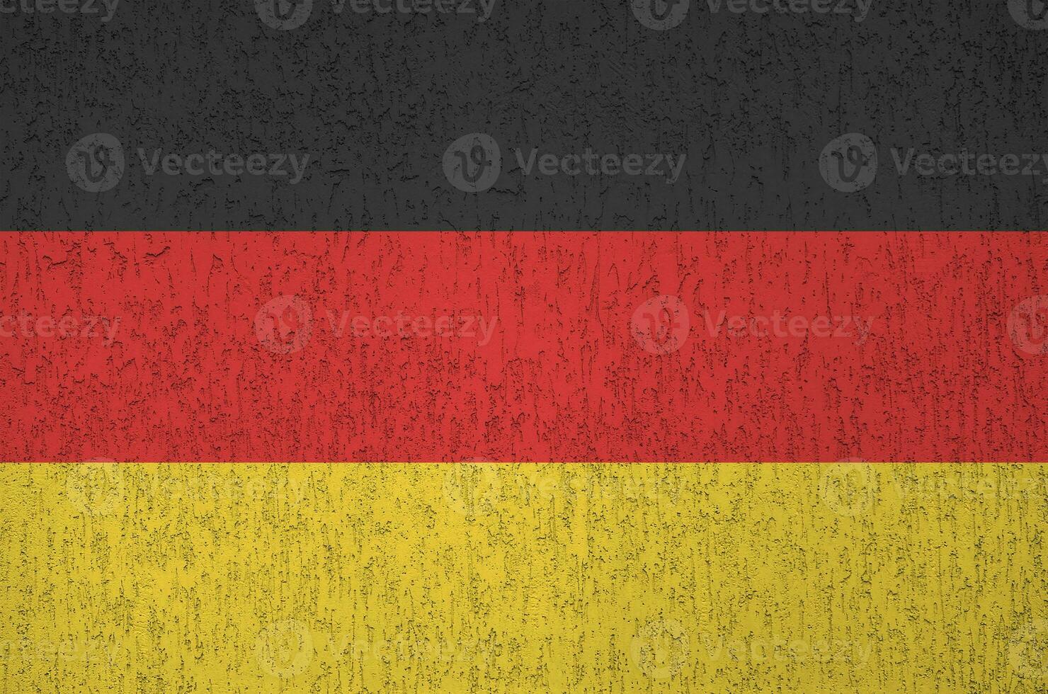 Germany flag depicted in bright paint colors on old relief plastering wall. Textured banner on rough background photo