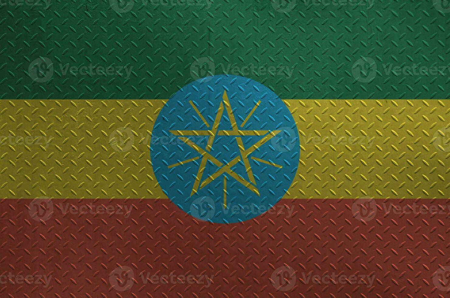 Ethiopia flag depicted in paint colors on old brushed metal plate or wall closeup. Textured banner on rough background photo