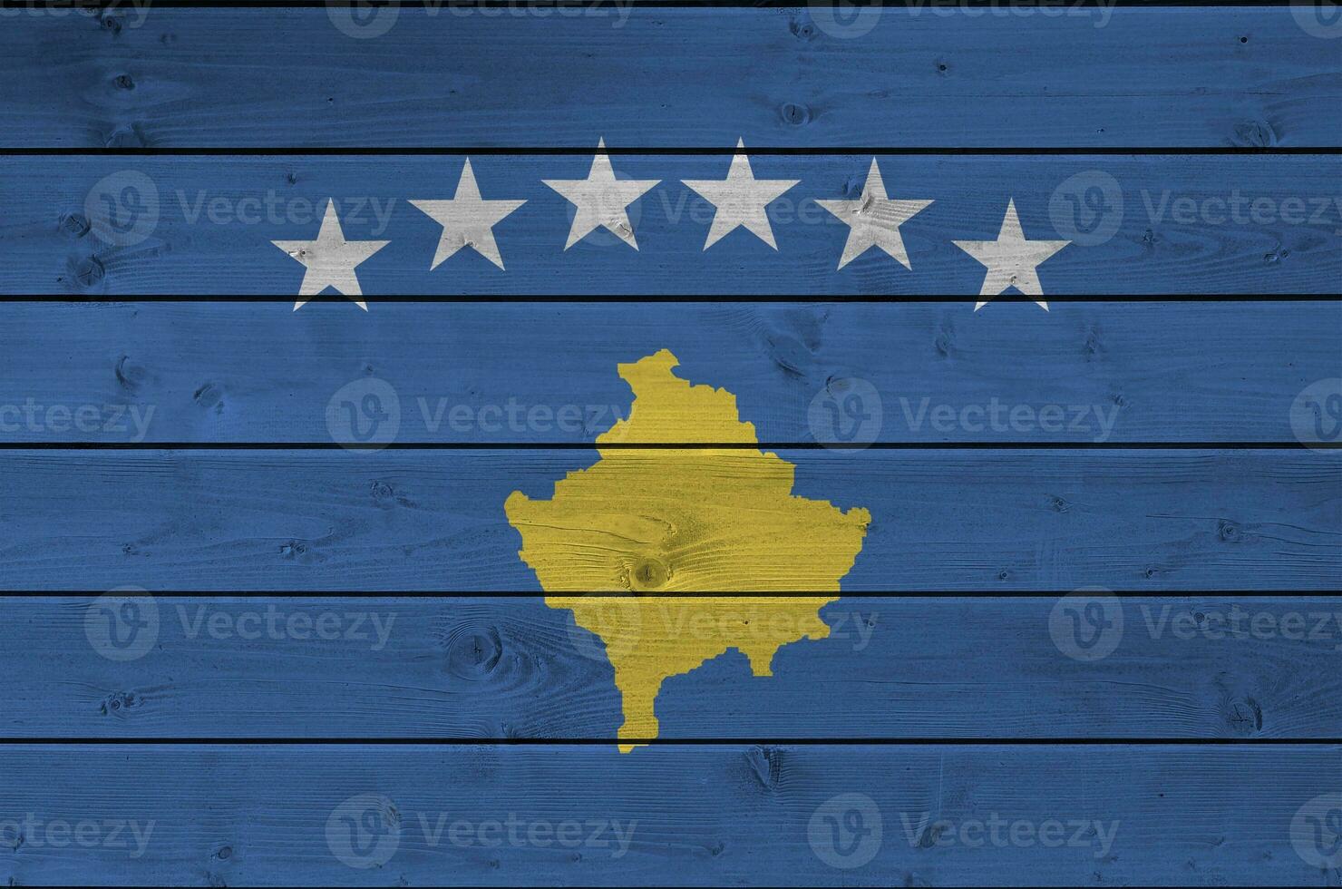 Kosovo flag depicted in bright paint colors on old wooden wall. Textured banner on rough background photo