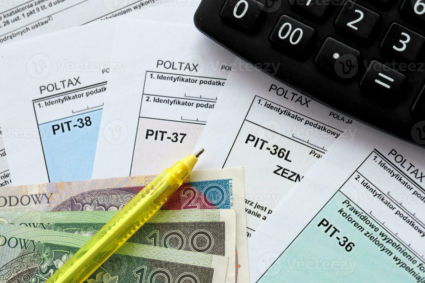 Declaration of the amount of earned income or incurred loss, PIT-36, PIT-36L, PIT-37 and PIT-38 tax forms on accountant table with pen and calculator photo