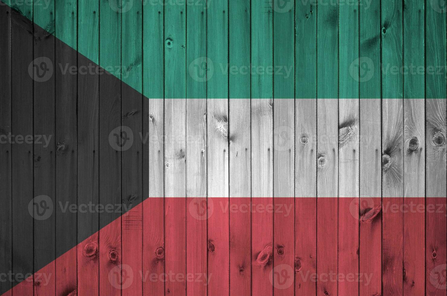 Kuwait bandera representado en brillante pintar colores en antiguo de madera pared. texturizado bandera en áspero antecedentes foto