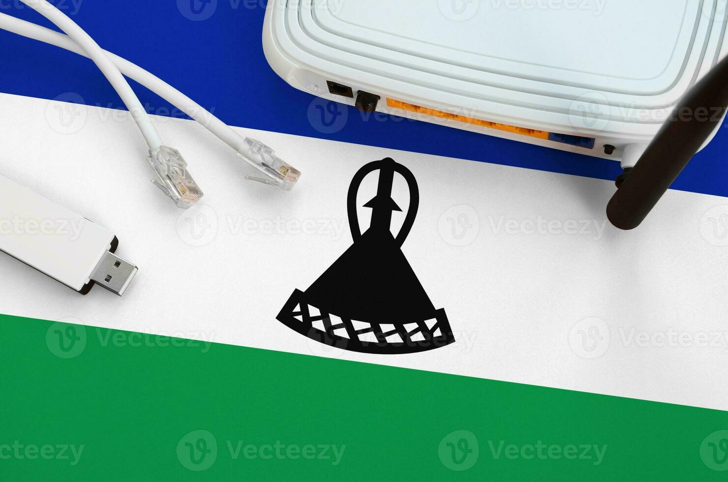 Lesotho flag depicted on table with internet rj45 cable, wireless usb wifi adapter and router. Internet connection concept photo