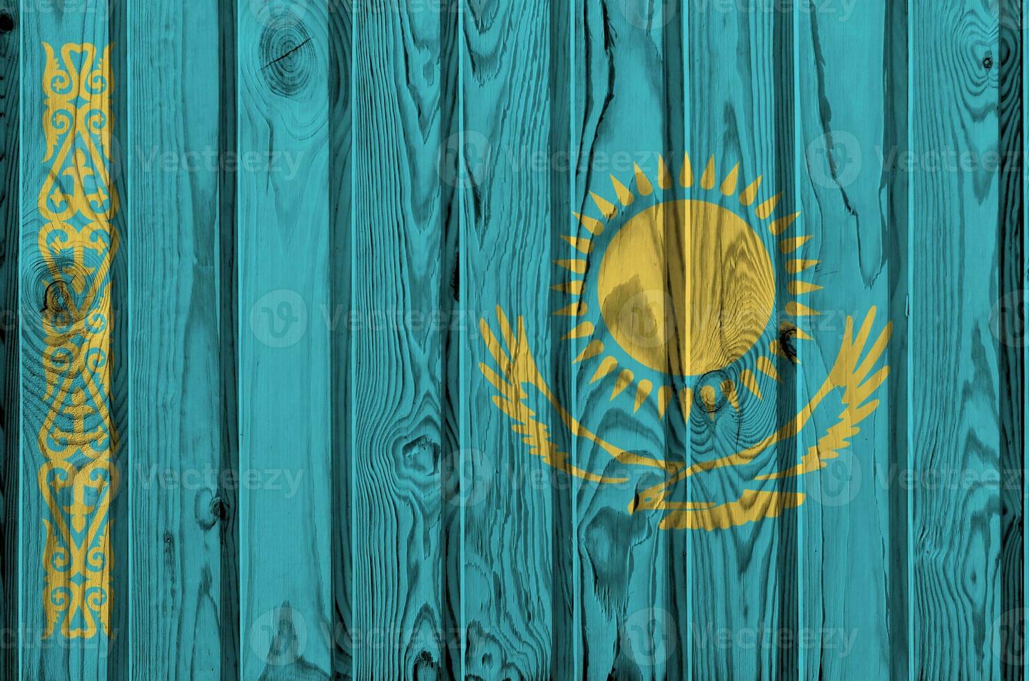 Kazakhstan flag depicted in bright paint colors on old wooden wall. Textured banner on rough background photo