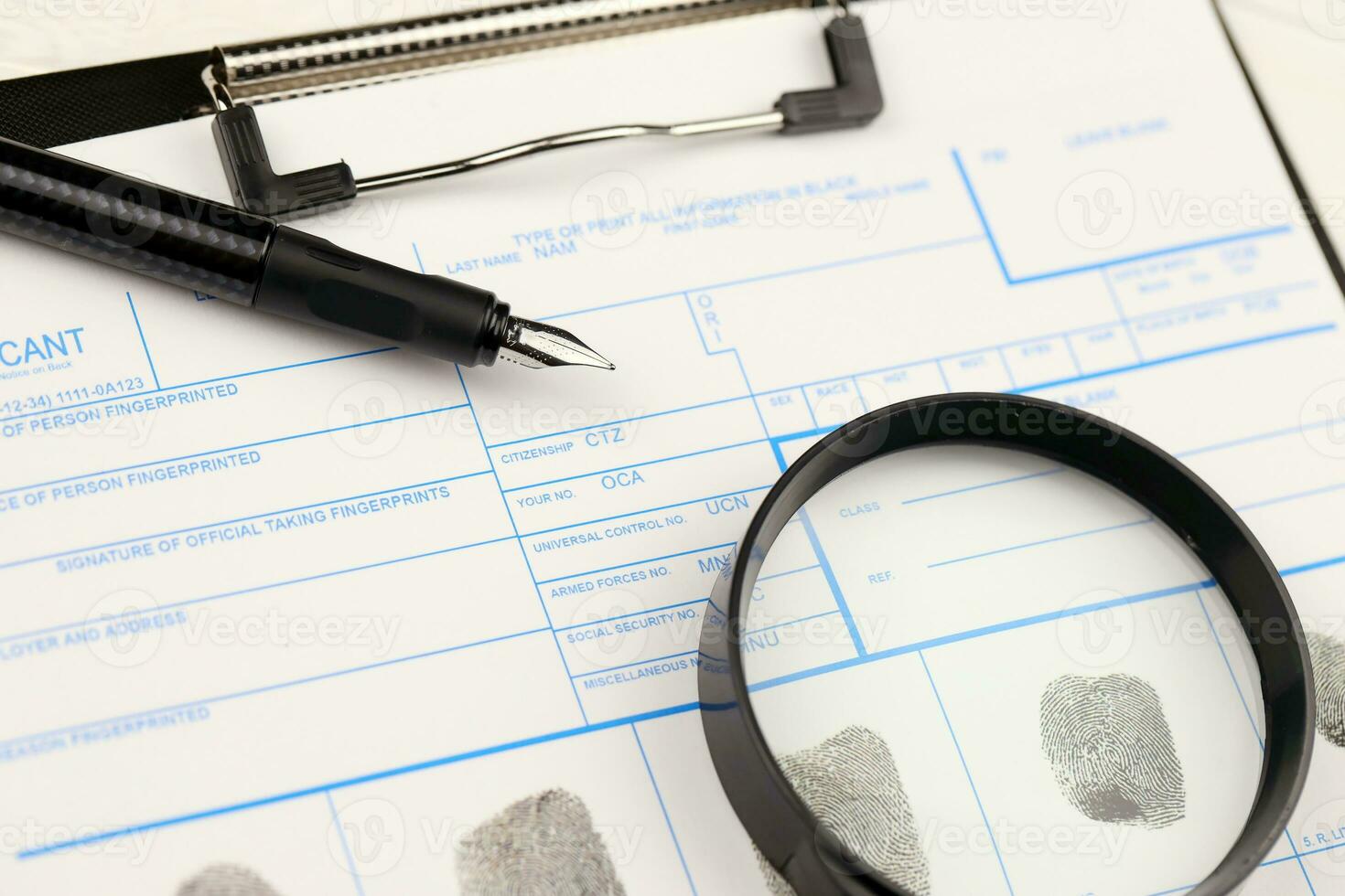 Fingerprints card police form on A4 tablet lies on office table with pen and magnifying glass photo