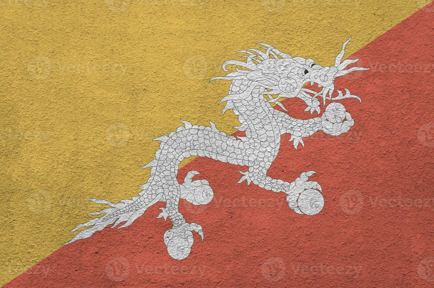 Bhutan flag depicted in bright paint colors on old relief plastering wall. Textured banner on rough background photo
