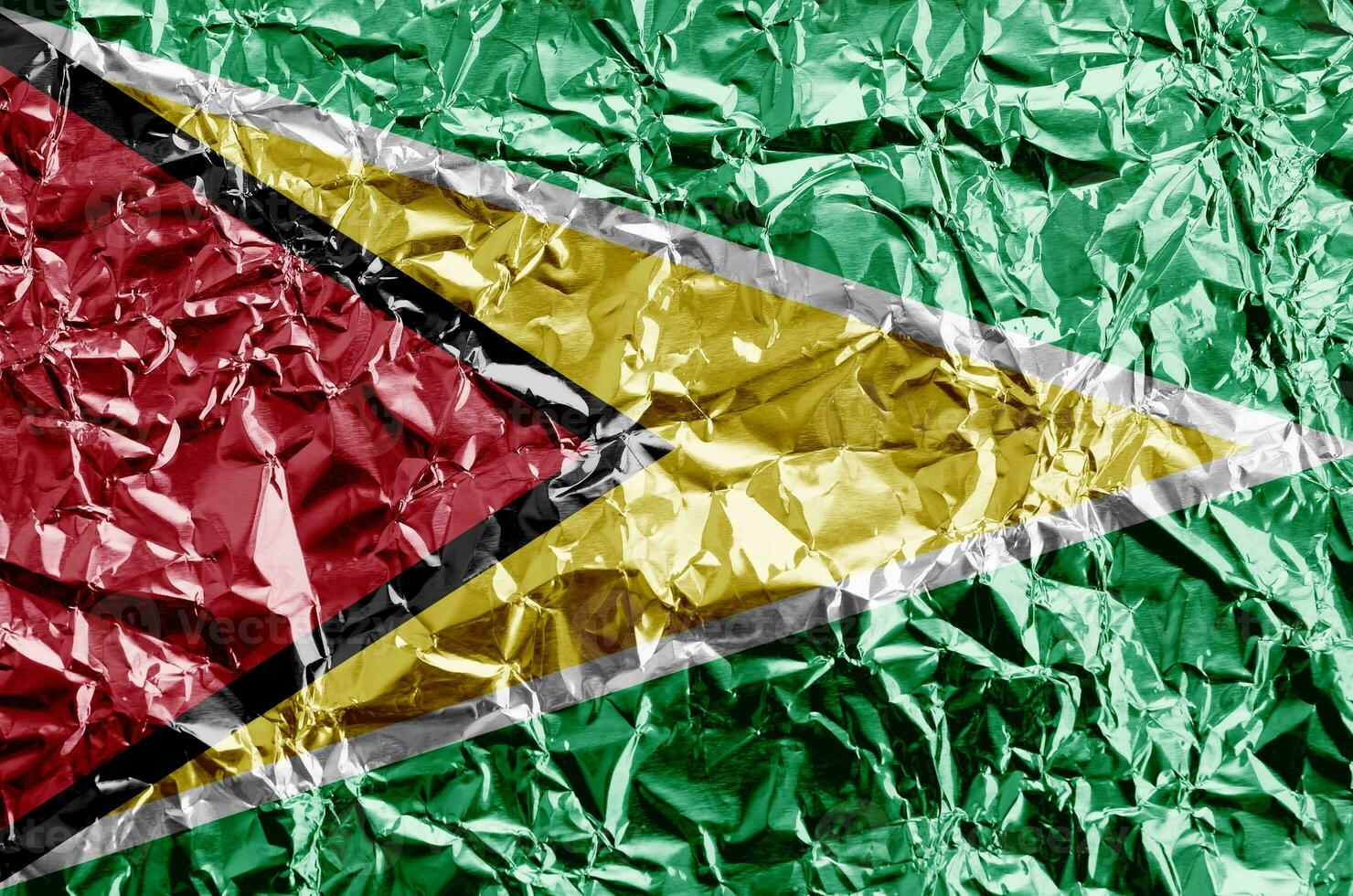 Guyana flag depicted in paint colors on shiny crumpled aluminium foil closeup. Textured banner on rough background photo