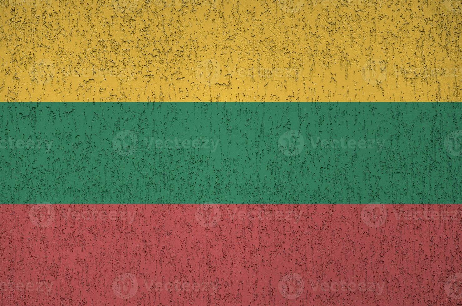 Lithuania flag depicted in bright paint colors on old relief plastering wall. Textured banner on rough background photo