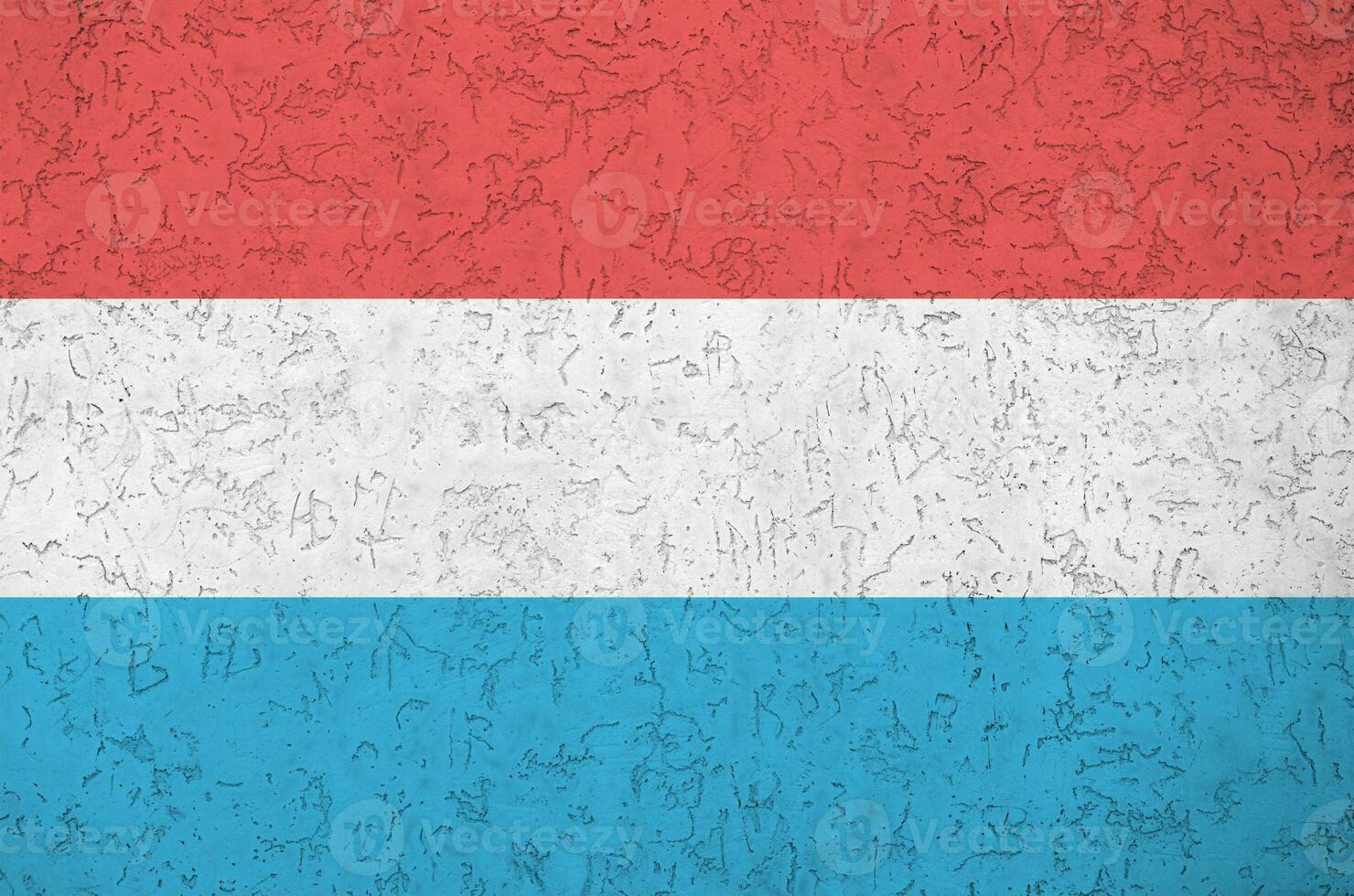 Luxembourg flag depicted in bright paint colors on old relief plastering wall. Textured banner on rough background photo