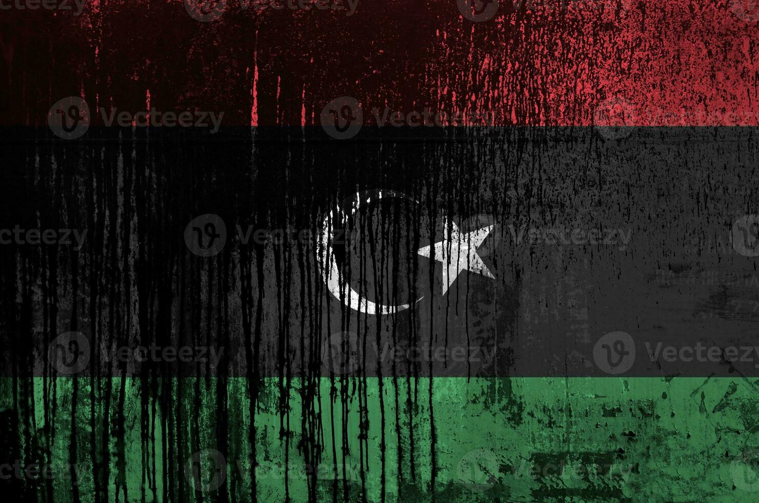 Libya flag depicted in paint colors on old and dirty oil barrel wall closeup. Textured banner on rough background photo