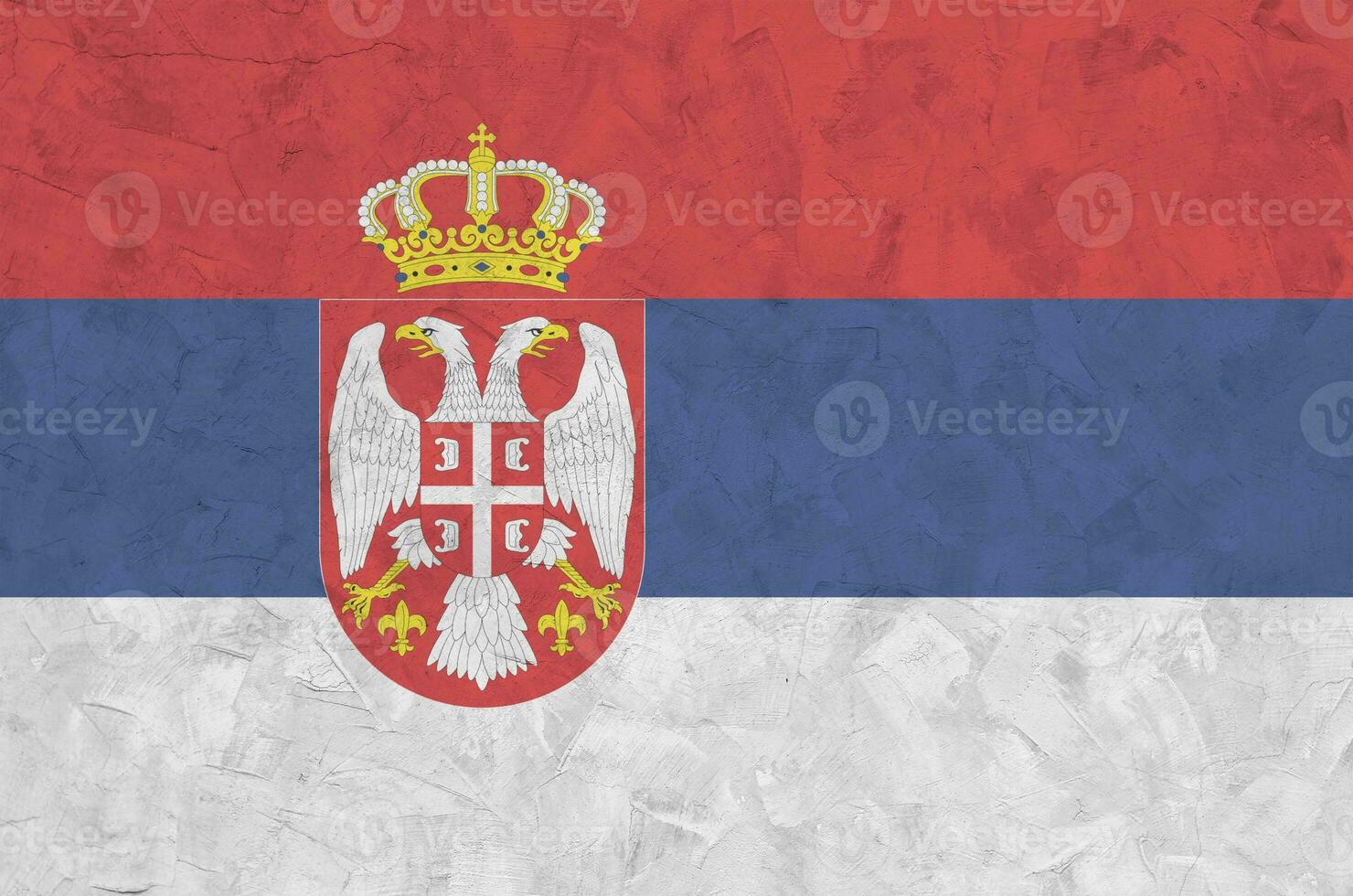 Serbia flag depicted in bright paint colors on old relief plastering wall. Textured banner on rough background photo