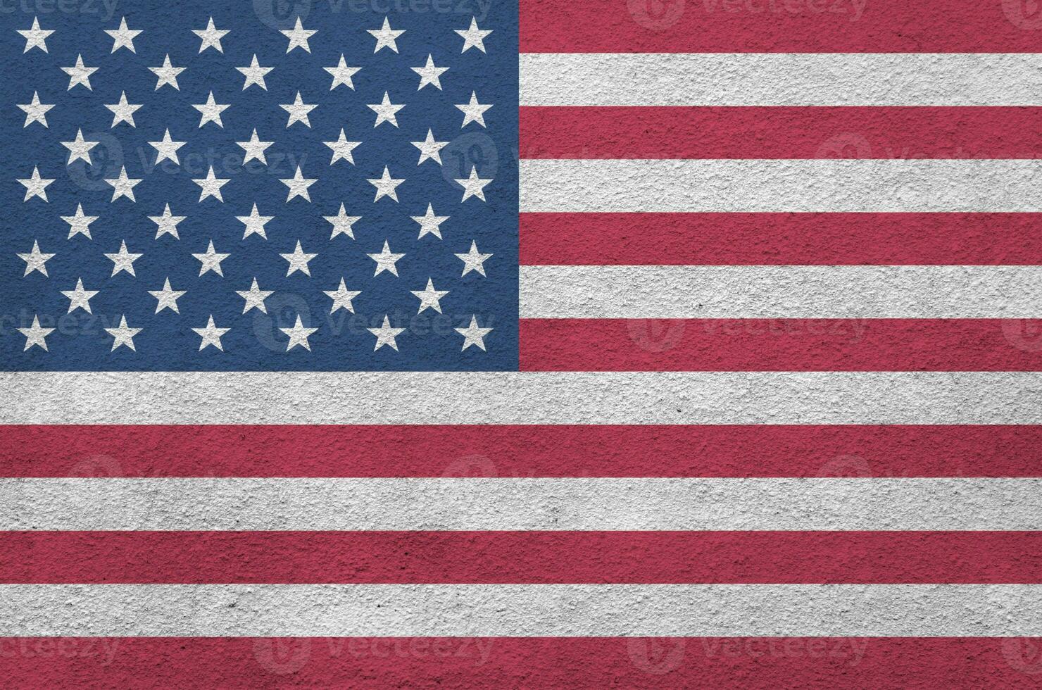 United States of America flag depicted in bright paint colors on old relief plastering wall. Textured banner on rough background photo