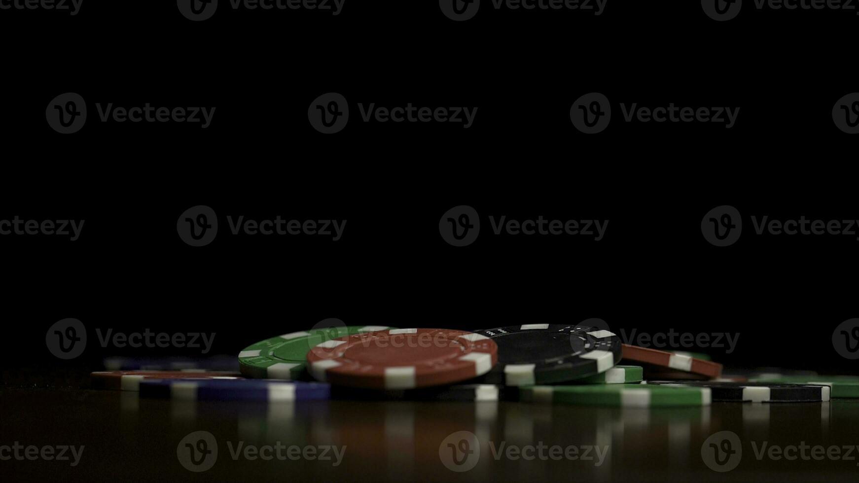 Falling poker chips isolated on black background. Colorful poker chips falling at the table on black background. Playing chips flying at the black background photo