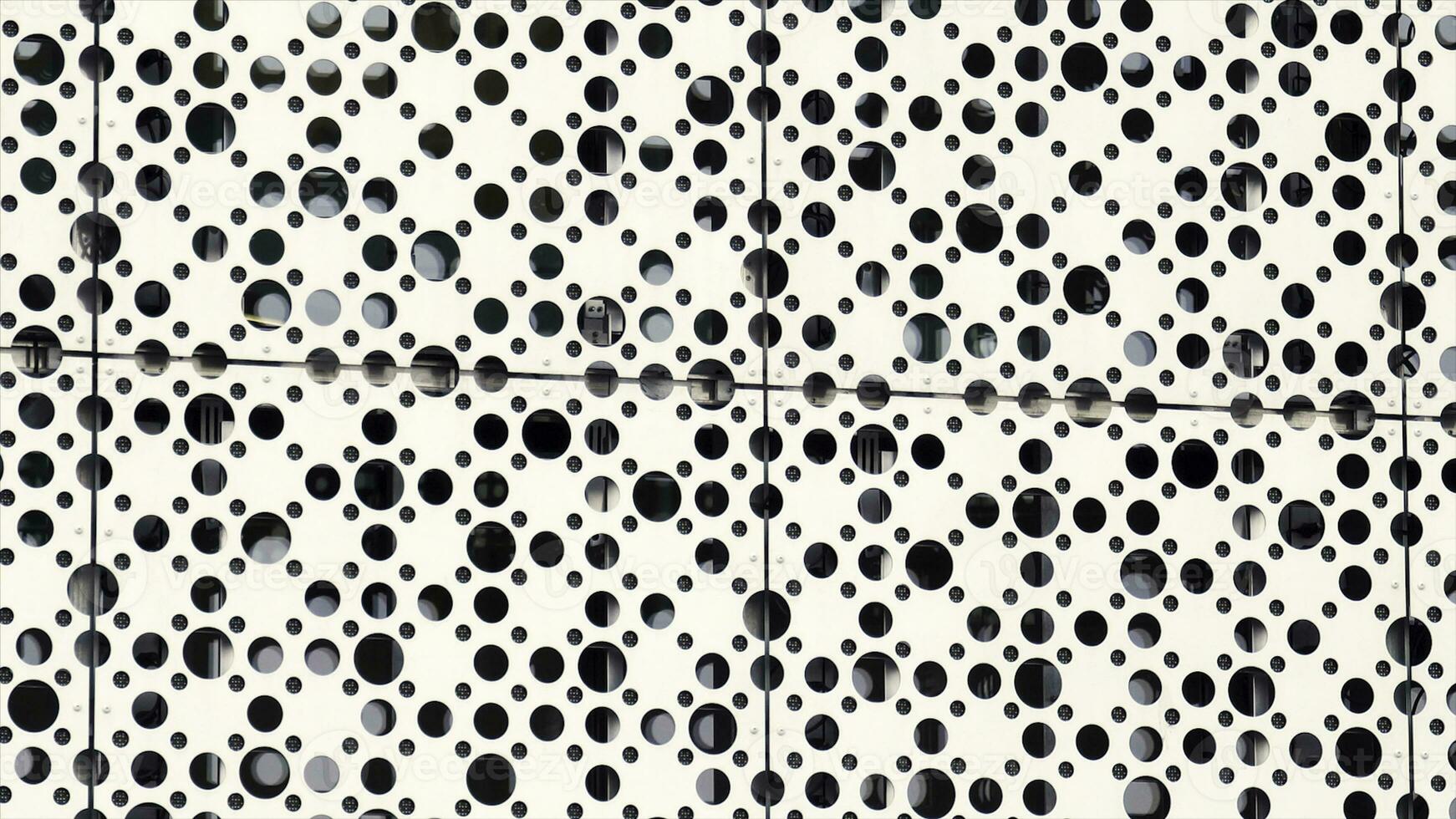 Metal holes of different size background, modern architecture concept. Grey metall wall with many small round holes, dotted pattern. photo