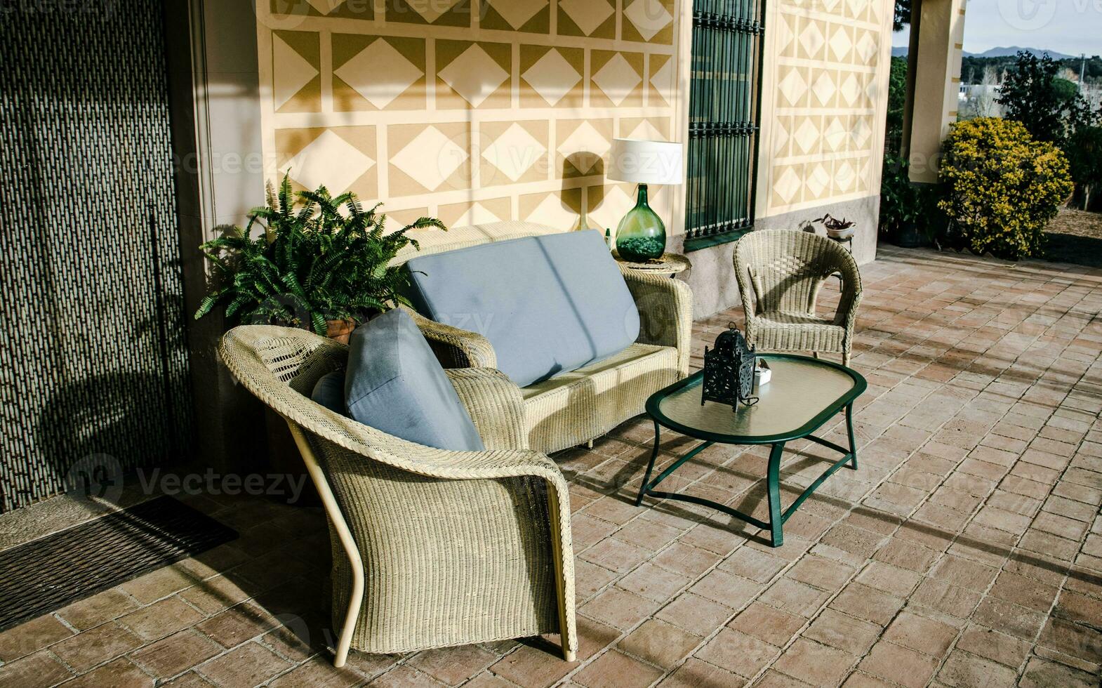 Dining coffee table with chairs on tile floor exterior. Living area in countryside house or hotel. photo