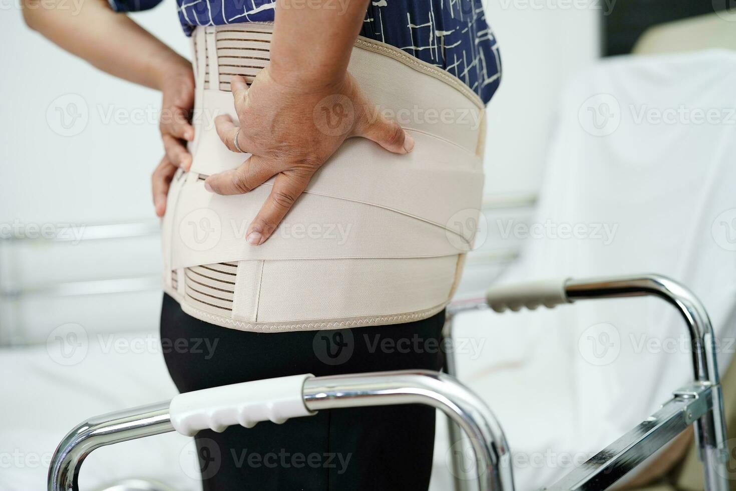 Asian senior wearing elastic support belt can help reduce back pain