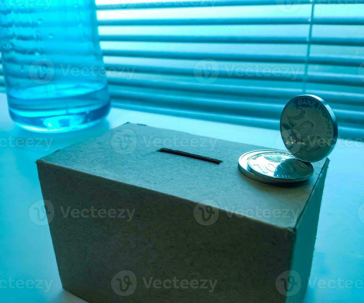 A Close up of box of savings and coins stacked. photo