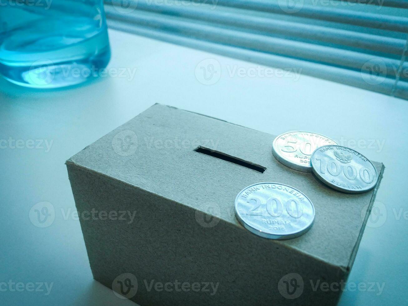 A Close up of box of savings and coins stacked. photo