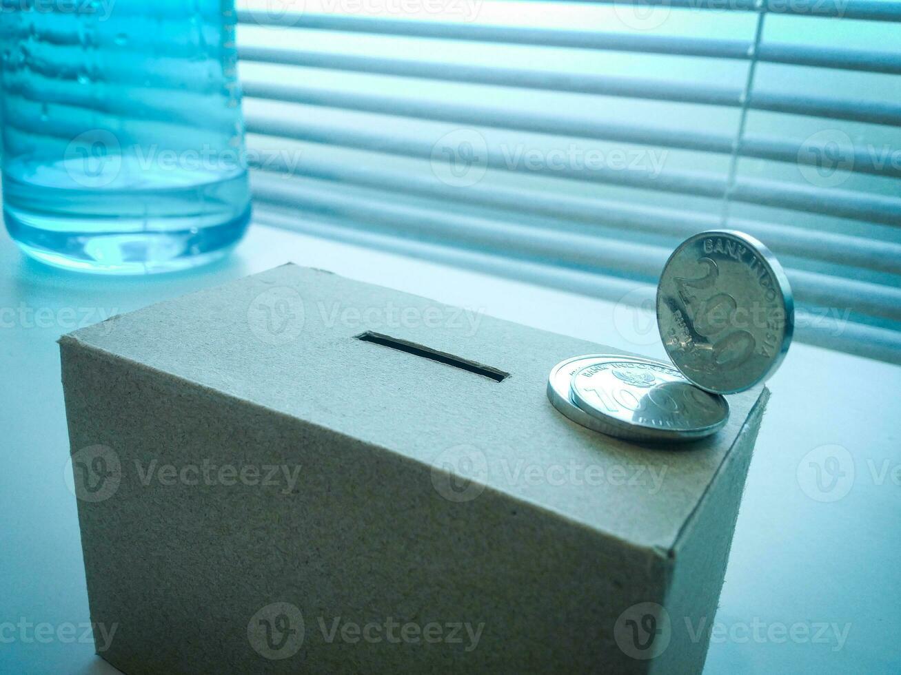 A Close up of box of savings and coins stacked. photo