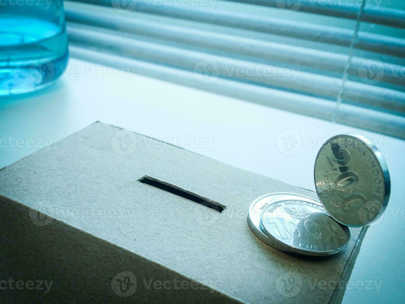 A Close up of box of savings and coins stacked. photo