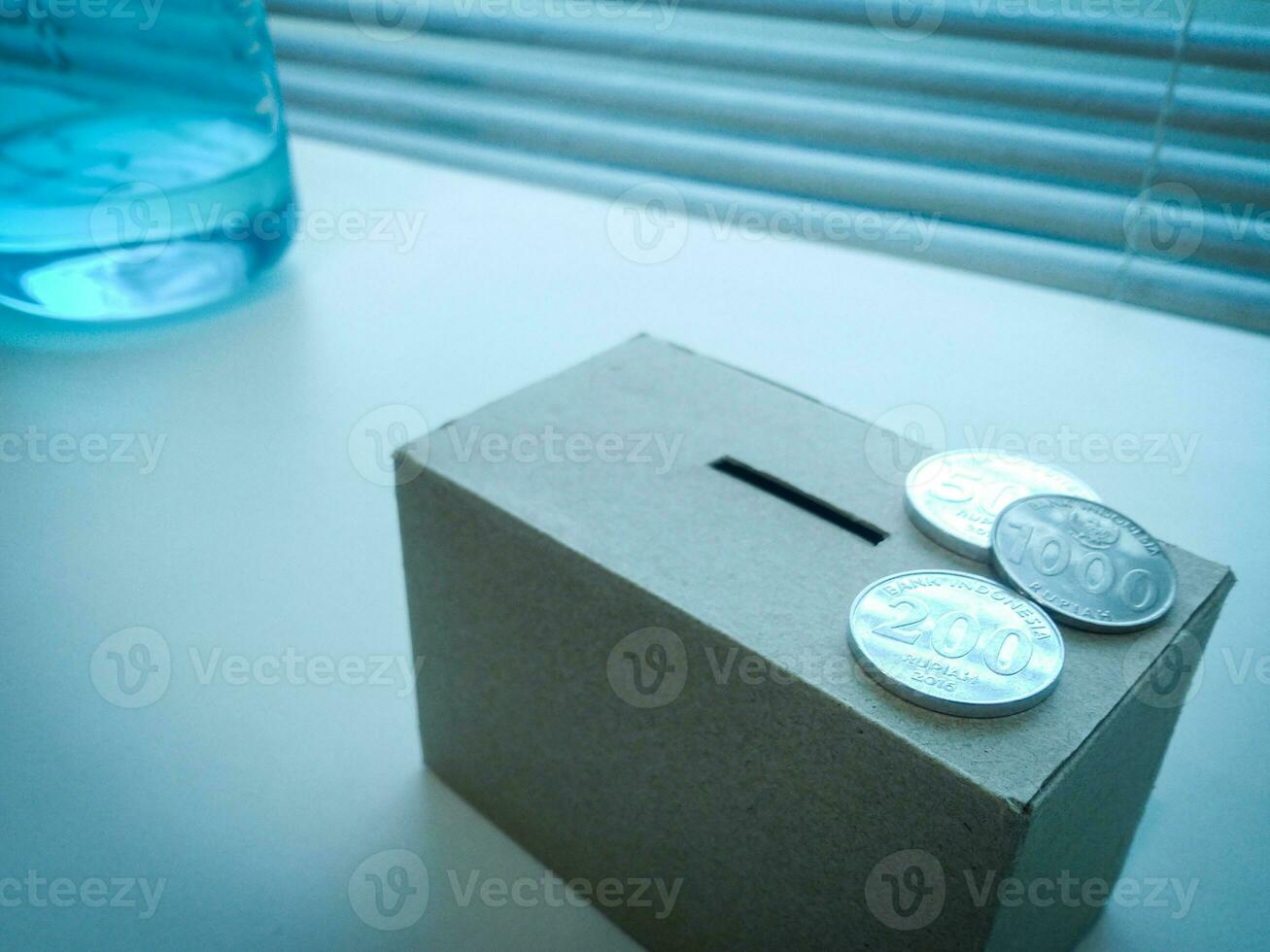 A Close up of box of savings and coins stacked. photo